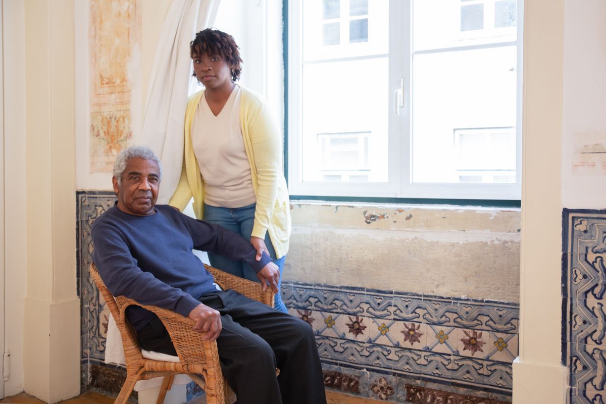 Older person with a companion by a window